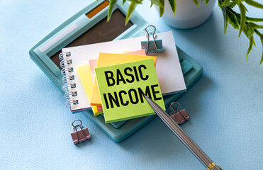 Basic income text on notepad, concept background