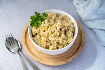 Cooked quinoa grain porridge in white bowl, healthy food