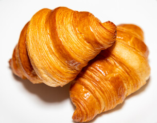 Golden brown butter croissant with shadow isolated on the plain background.