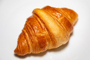 Golden brown butter croissant with shadow isolated on the plain background.