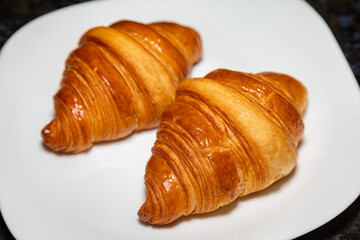 Golden brown butter croissant with shadow isolated on the plain background.