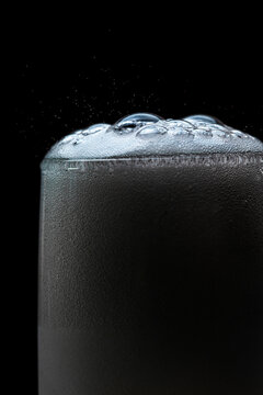 Champagne bubbles popping over flute glass in closeup macro photograph