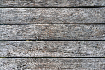 Alte und verwitterte Bretter eines Stegs als Holztextur oder h&ouml;lzerner Hintergrund