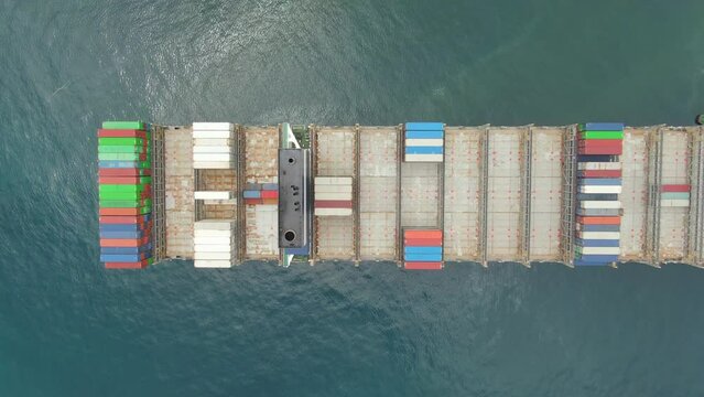 Aerial view above the ultara large container ship, view on cargo area, crew living quarter and scrubber funnel