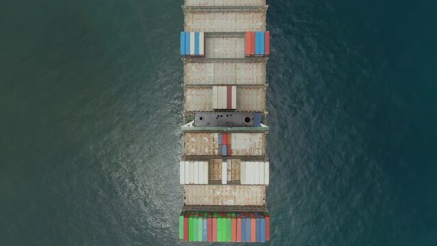 Aerial view above the ultara large container ship, view on cargo area, crew living quarter and scrubber funnel