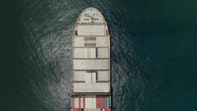 Aerial view above the ultara large container ship, view on cargo area, crew living quarter and scrubber funnel