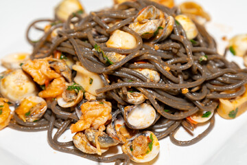 Black spaghetti with sepia squid ink with seafood, clams and shells. Nero di seppia