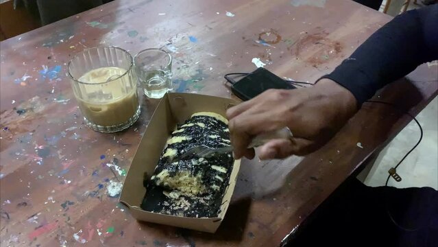 Footage A man is cutting cubit cake using a fork
