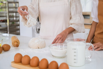 Woman kneading dough on the table.