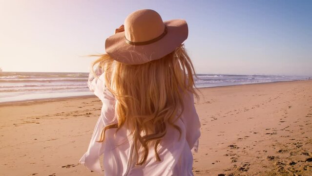 Attractive blond woman at the beach at sunset in Southern California. Slow Motion.