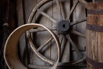 Old authentic wooden wheel from a cart in a rustic barn.