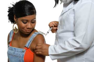 a black teenager being vaccinated in the arm by a health professional