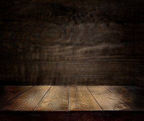 An empty wooden countertop against a black, dark concrete wall. Home interior. Evening, dim light....