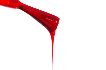 Red dripping nail polish brush. On a white background