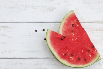 Fototapeta na wymiar Pieces of watermelon, tower culture, black seeds, on a white wooden table, berry, hello summer, vitamins, photo background