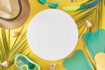 Seaside vacation concept. Top view flat lay of diving mask with snorkel, flippers, trendy sun hat, seashells and palm leaves on yellow background with blank circle for text or promotion