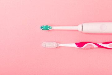 electric toothbrush, bamboo and handmade toothbrushes on a pink background with copy space. Flat lay. Oral hygiene. Oral care kit. Dentist concept. Place for text. Place to copy.