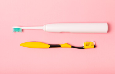 electric toothbrush, bamboo and handmade toothbrushes on a pink background with copy space. Flat lay. Oral hygiene. Oral care kit. Dentist concept. Place for text. Place to copy.