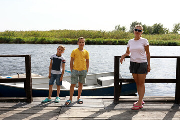 Mother with two her sons posing on river bank