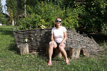 Woman sitting on stump in backyard