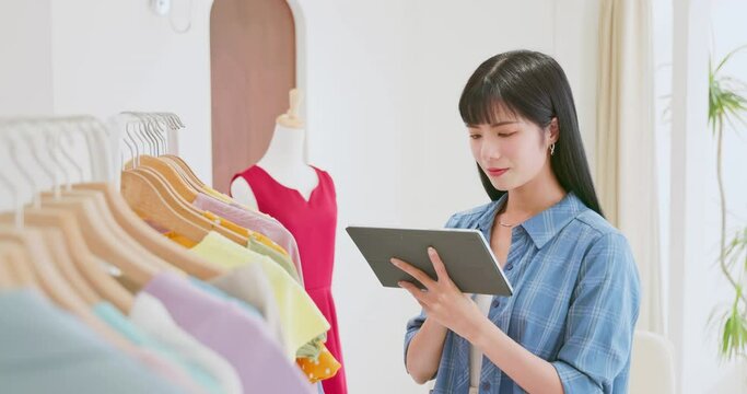 asia clerk checking clothes stock