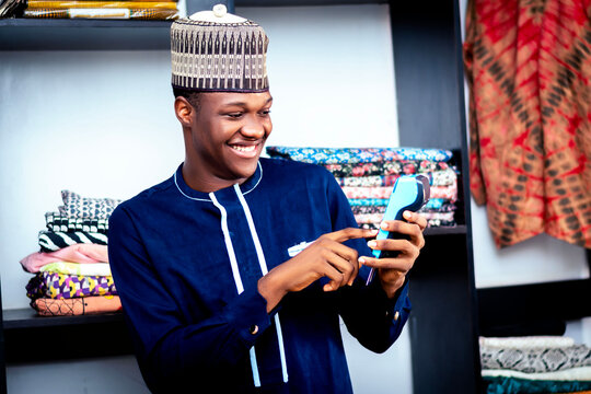 A man in a blue shirt is looking and typing code on a pos machine