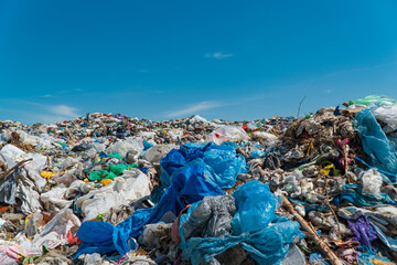 A pile of garbage in a landfill against a blue sky. Plastic scrap in landfill. Concept of ecology