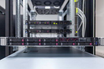 Rackmount chassis with installed servers hardware in datacenter, front view from the control panel units. Selective focus.