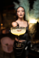 beautiful girl in an evening dress is holding a drink with lipstick imprint on the glass. selective focus