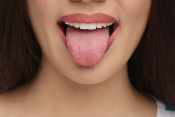 Woman with nude lipstick showing her tongue, closeup