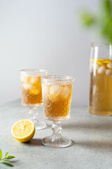 Black tea with ice and lemon in a tall glass. Cold lemonade. 