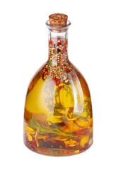 Glass jug of cooking oil with spices and herbs isolated on white