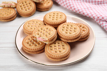 Fototapeta na wymiar Tasty sandwich cookies with cream on white wooden table