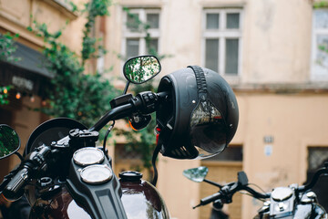 a motorcyclist's helmet hangs on the handlebars of a motorcycle