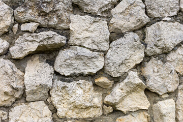 the wall is made of natural material, stone is a limestone material of volcanic origin used for construction purposes.