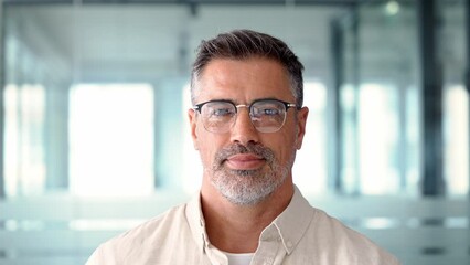Headshot close up portrait of indian or latin confident mature good looking middle age leader, ceo male businessman on blur office background. Handsome hispanic senior business man looking at camera. - Powered by Adobe