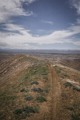 Trail on ridgeline of grassy hill in badlands terrain in Montrose Colorado