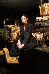 beautiful sensual girl sitting on the counter of a nightclub