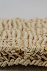 Dry instant ramen noodles on white background.