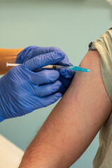 Person getting a Covid vaccine shot in the right shoulder.