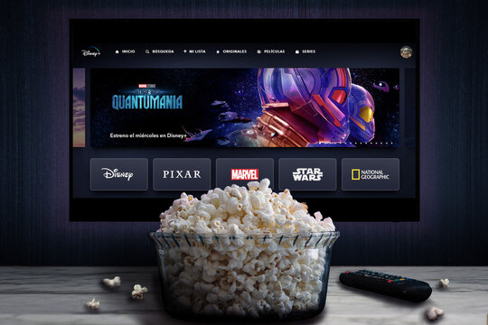 Cali, Colombia - May 20, 2023: Disney Plus app on tv screen playing "Ant-Man and the Wasp: Quantumania" behind a bowl of popcorn and a remote control.