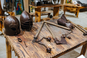Medieval weaponry and helmets on a table at a museum