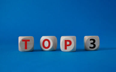Top 3 symbol. Concept word Top 3 on wooden cubes. Beautiful blue background. Business and Top 3 concept. Copy space.