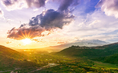 beautiful travel mountain landscape, nice sunset with amazing view from highland to a valley with picturesque mountain town