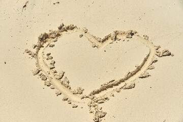 A heart painted on the sand on the beach as a symbol of love.