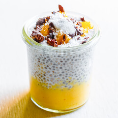 chia and coconut pudding with mango mousse and cacao beans
