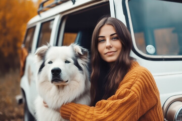 Young woman and her dog next to the car on a beautiful autumn day