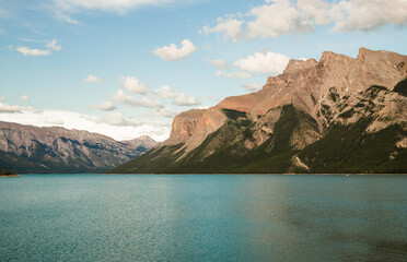 Mountain lake landscape panorama wihout people - forest, scenic blue lake and Rocky Mountains on horizon background. Minnewanka lake, Banff provincial park, Alberta, Canada