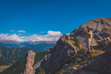 A male hiker taking photos from the top of Col du Cros (French Alps)