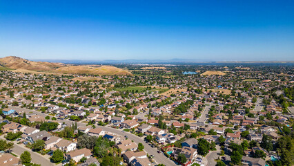 .A breathtaking aerial view of Antioch, California: houses nestled amidst verdant hills,...